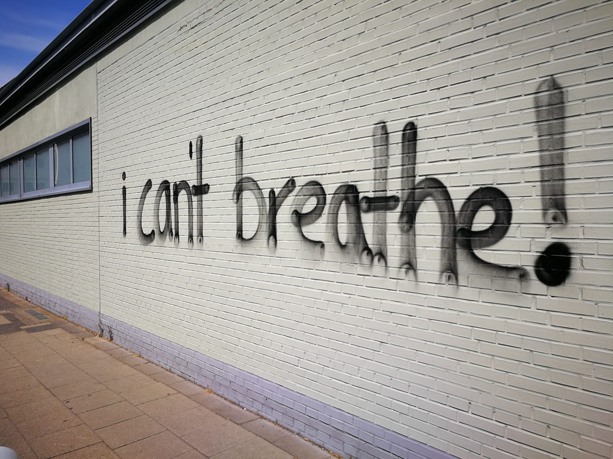 Graffiti « I can't breathe » sur mur de briques