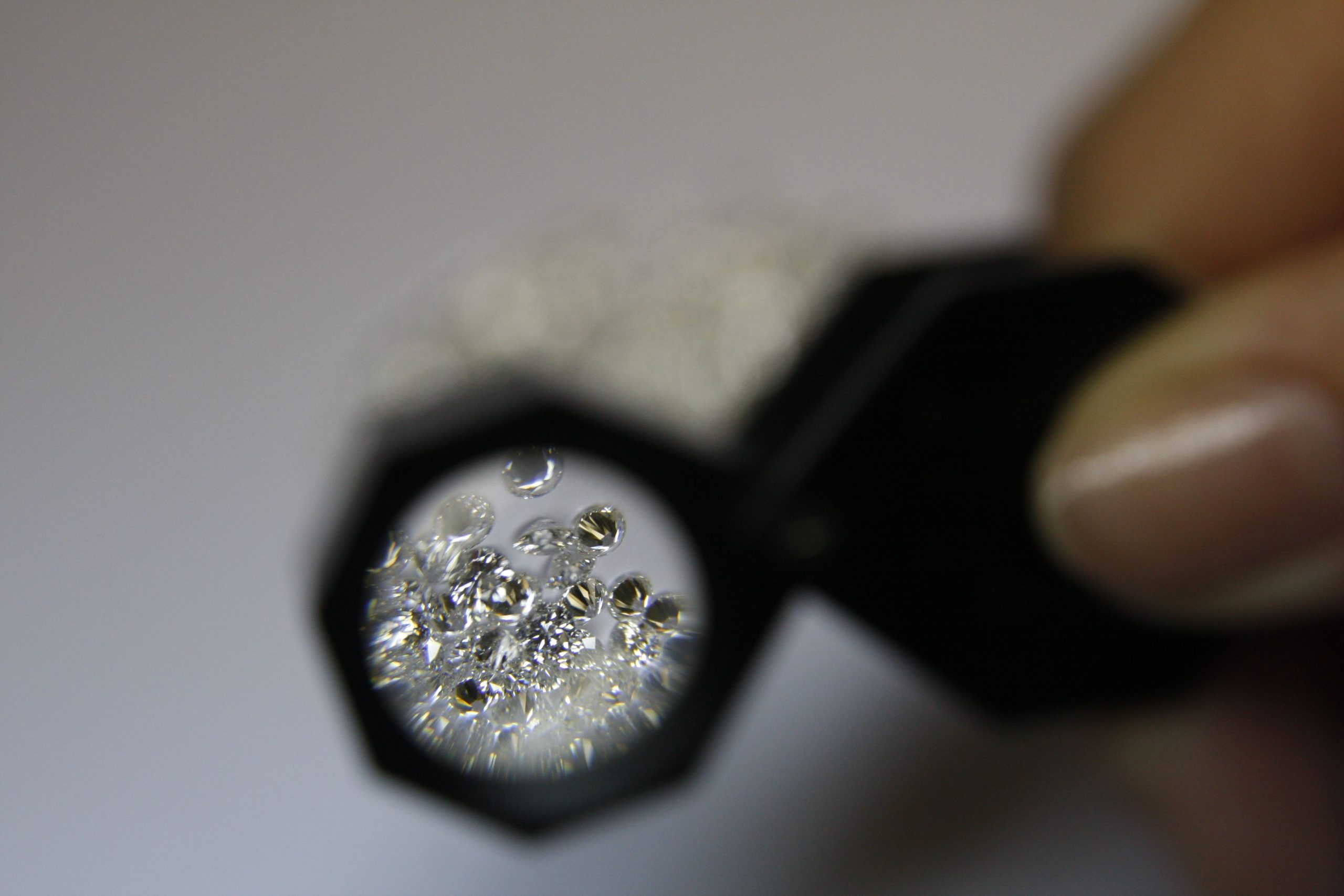 Joaillière examine diamants loupe atelier