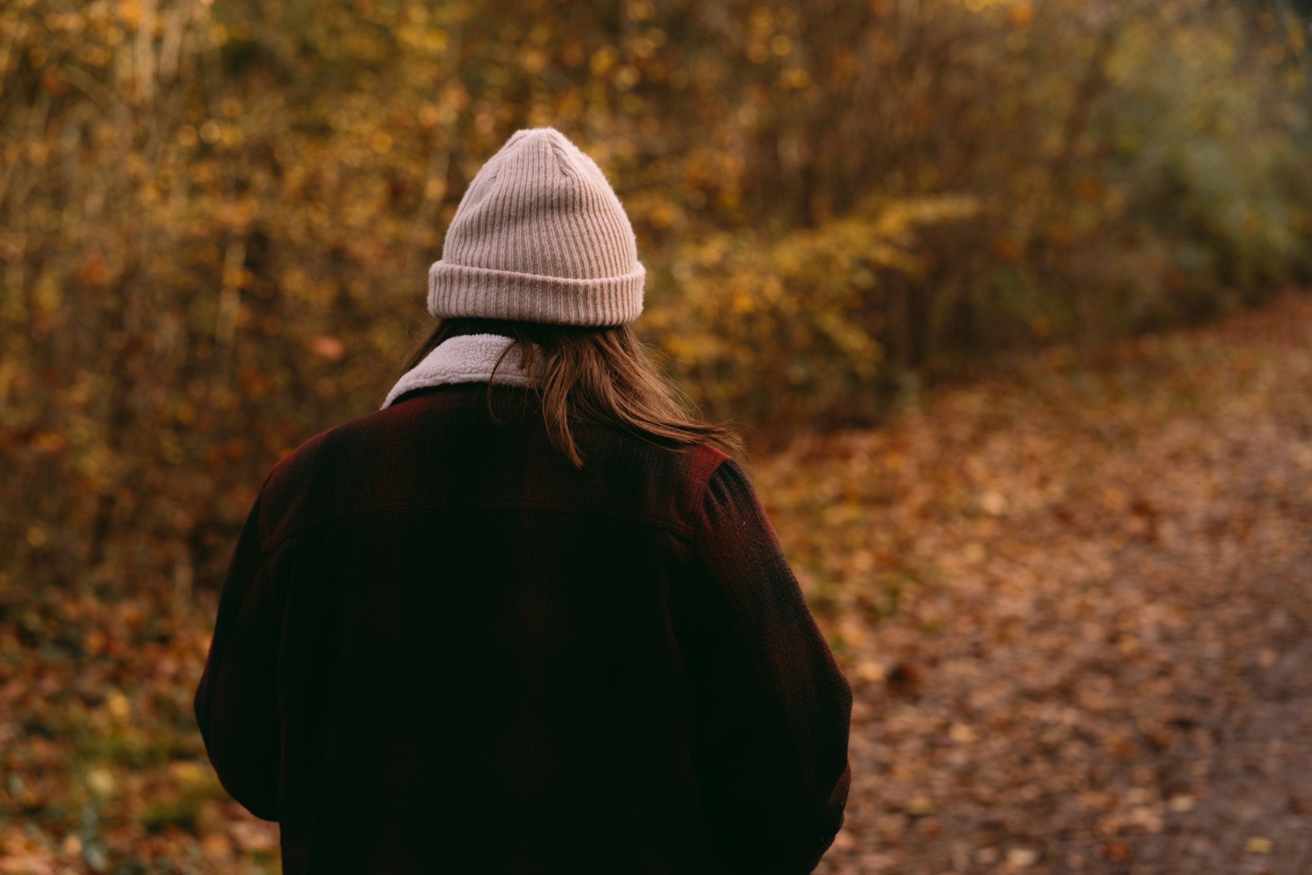 Femme bonnet traverse forêt automne sereine