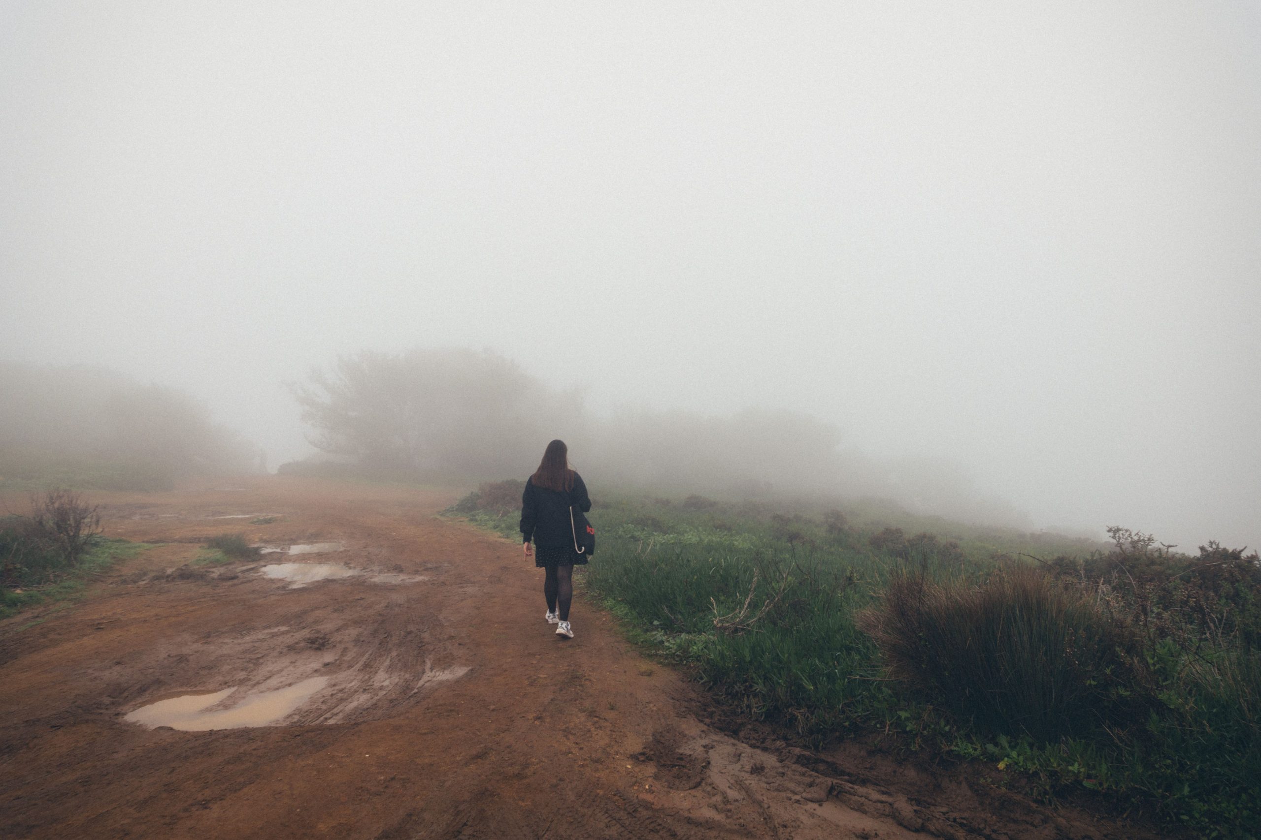 Femme sur chemin brumeux entouré nature