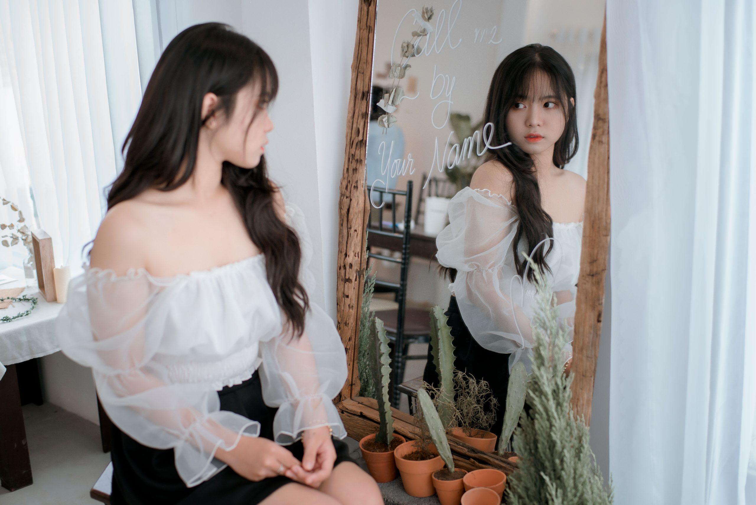 Femme élégante en blouse blanche face au miroir