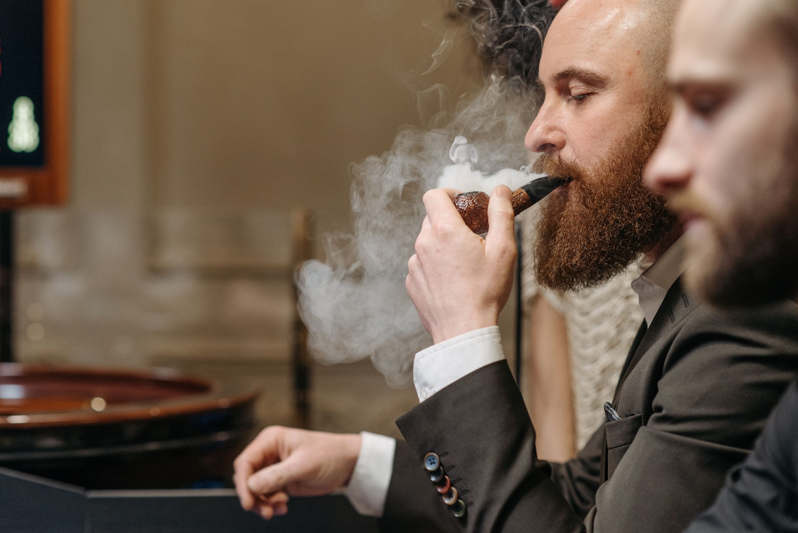 Homme en costume fumant la pipe