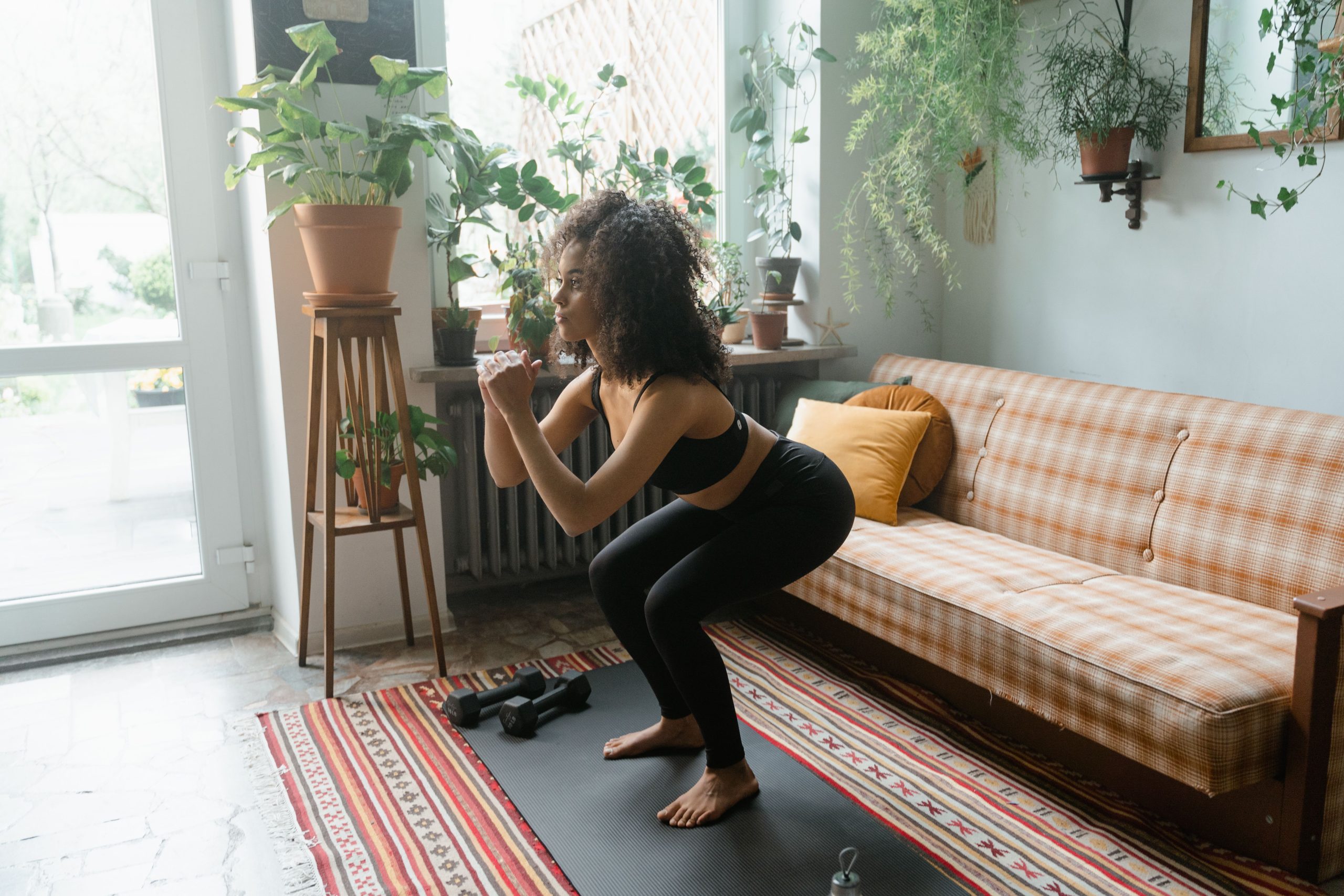Femme en tenue de sport faisant des squats sur un tapis