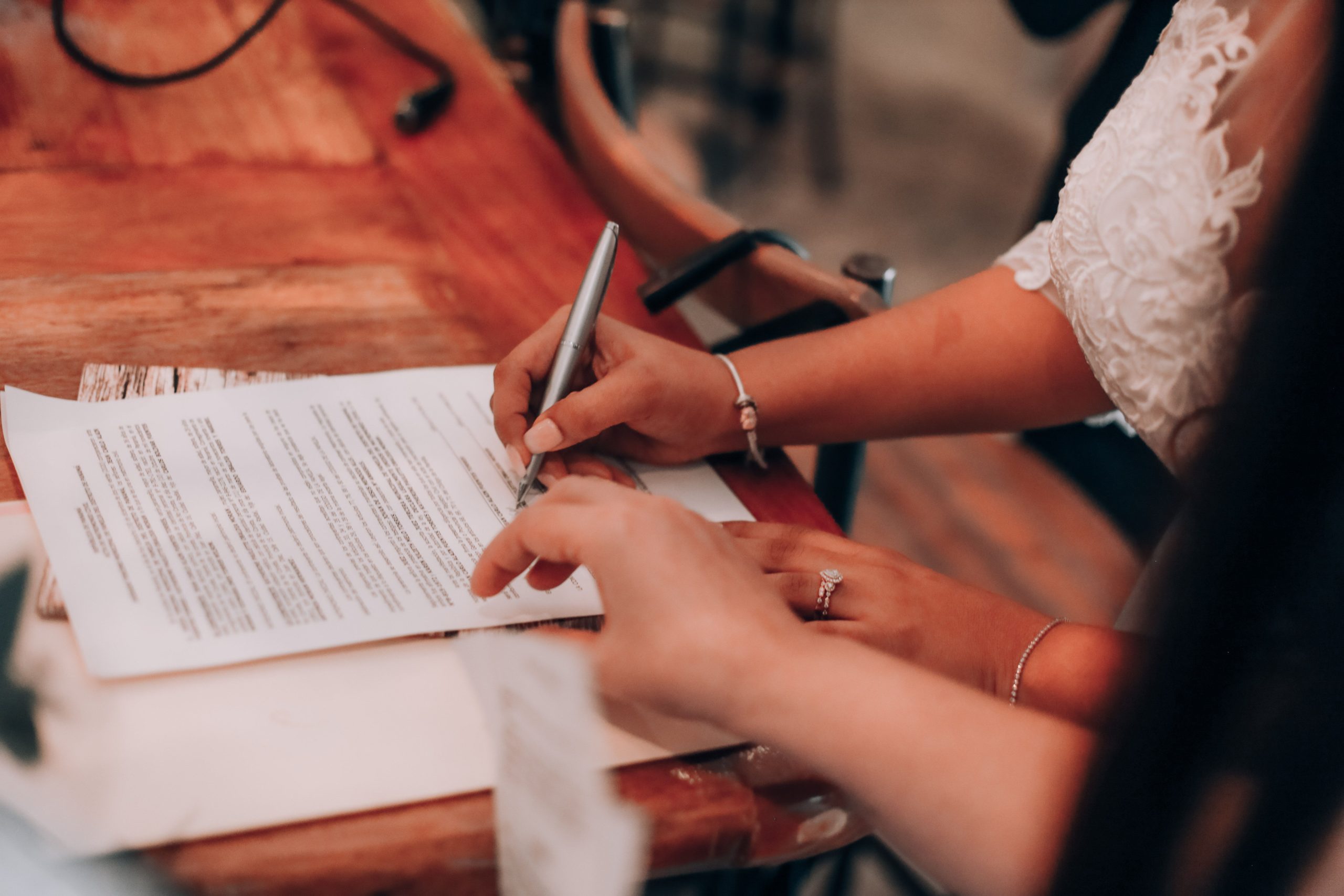Mains signant un document important sur une table